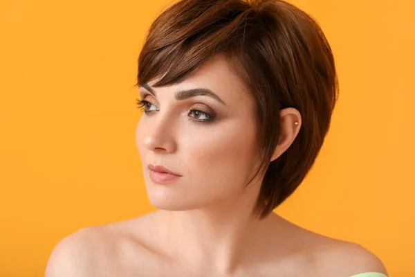 stock image Young woman with beautiful short hair on color background