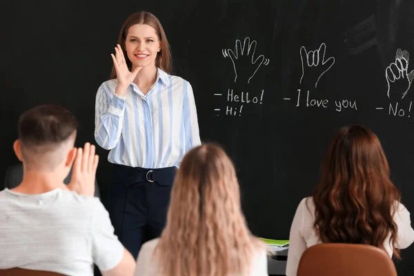 Teacher conducting courses for deaf mute people in classroom