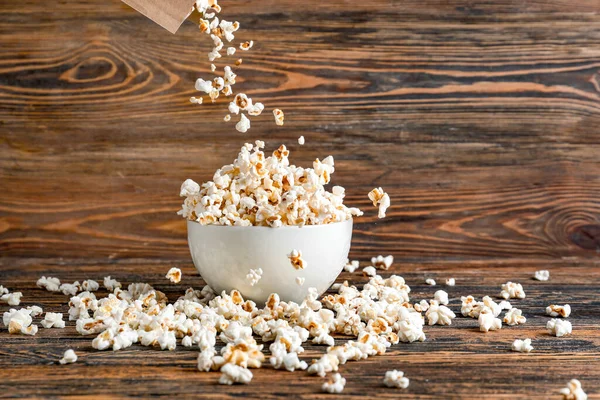 Throwing Tasty Popcorn Bowl Wooden Background — Stock Photo, Image