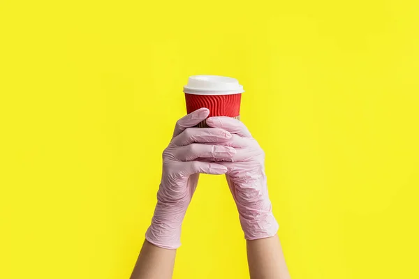 Χέρια Προστατευτικά Γάντια Και Φλιτζάνι Καφέ Στο Φόντο Χρώμα — Φωτογραφία Αρχείου