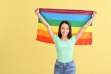 Renkli arka planda LGBT bayrağı olan genç bir kadın
