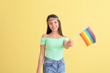 Renkli arka planda LGBT bayrağı olan genç bir kadın