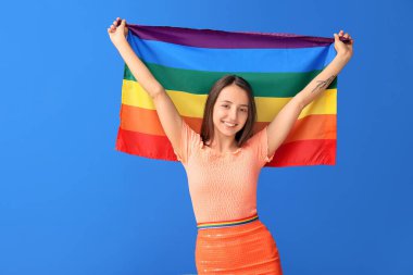 Renkli arka planda LGBT bayrağı olan genç bir kadın