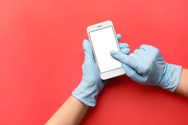 Renkli arka planda cep telefonu olan doktorların elleri