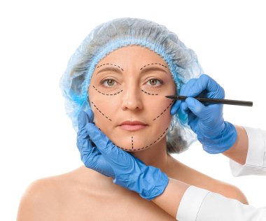 Plastik cerrah beyaz arka planda kadınların yüzüne izler yapıştırıyor.