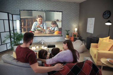 Evde film izleyen genç bir aile.