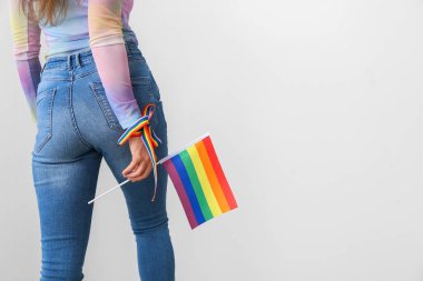 Hafif arkaplanda LGBT bayrağı olan genç bir kadın