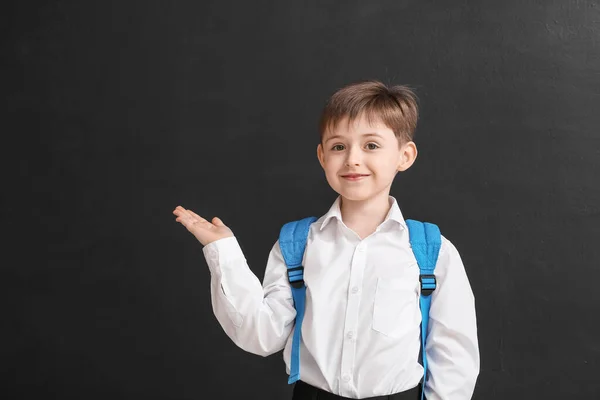 Piccolo Scolaro Mostrando Qualcosa Sfondo Scuro — Foto Stock