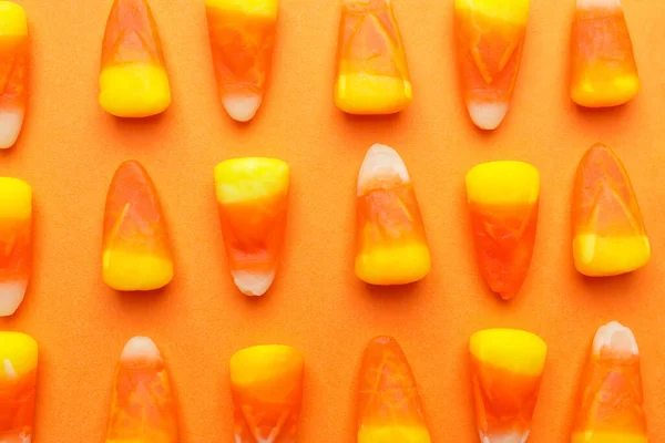 Tasty candies for Halloween on color background