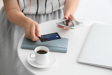 Genç bir kadın internetten alışveriş yapıyor.