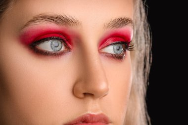 Koyu arka planda güzel göz falı olan genç bir kadın. Yakın plan.