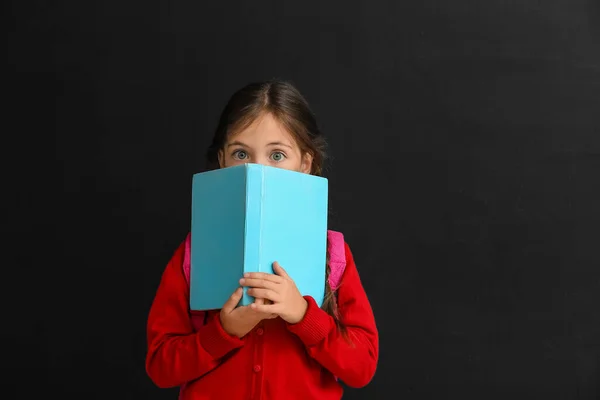 Kleines Schulmädchen Mit Buch Auf Dunklem Hintergrund — Stockfoto