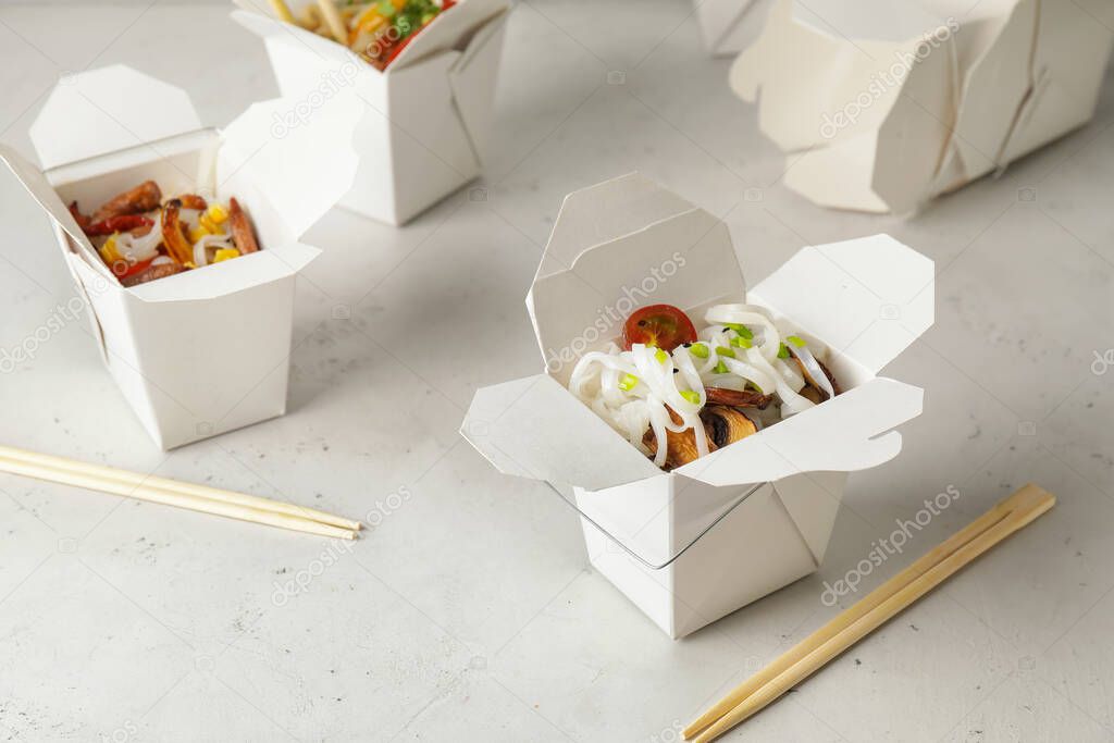 Boxes with with tasty rice noodles on white background