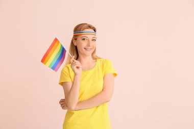 Renk arkaplanında LGBT bayrağı olan kadın
