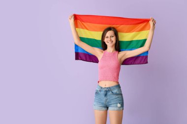 Renkli arka planda LGBT bayrağı olan genç bir kadın