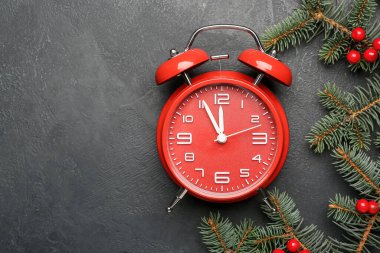 Alarm saati ve gri arkaplanda köknar dalları. Noel zamanı