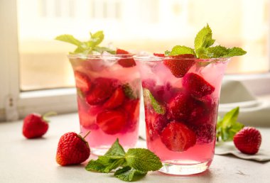 Pencere eşiğinde taze çilekli mojito bardakları.