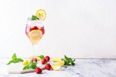 Hafif arkaplanda bir bardak taze çilekli mojito.