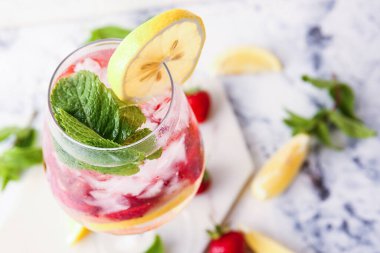 Hafif arka planda bir bardak taze çilekli mojito, yakın plan.