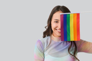 Hafif arkaplanda LGBT bayrağı olan genç bir kadın