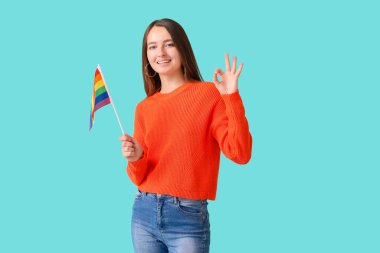 Renkli arka planda LGBT bayrağı olan genç bir kadın