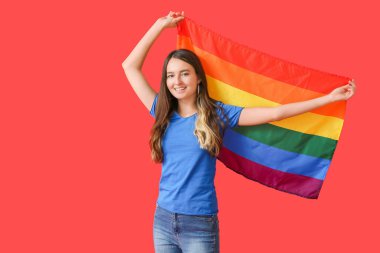 Renkli arka planda LGBT bayrağı olan genç bir kadın