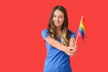 Renkli arka planda LGBT bayrağı olan genç bir kadın