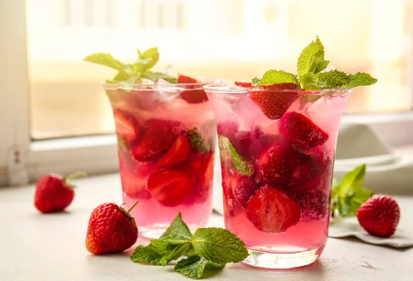 Pencere eşiğinde taze çilekli mojito bardakları.