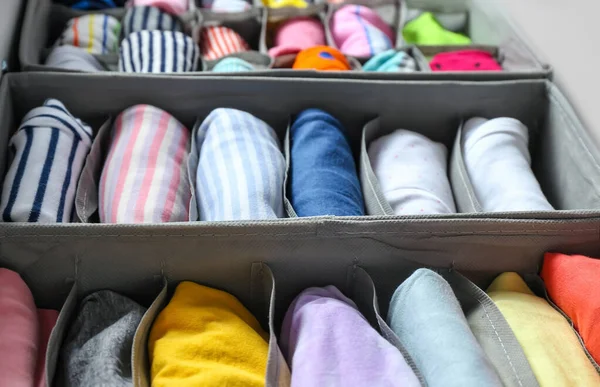 Organizers with clean clothes in closet