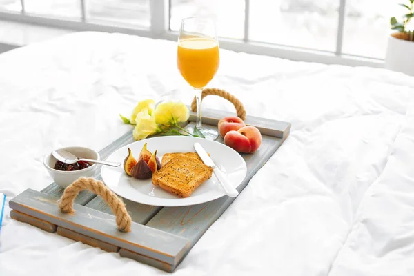 有美味早餐的盘子在床上 — 图库照片