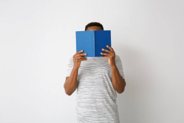 Açık arkaplan üzerine kitap okuyan Afro-Amerikalı bir adam