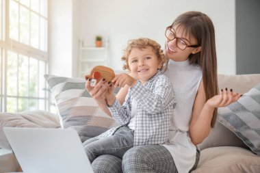 Evde oğluyla birlikte çalışan bir anne.