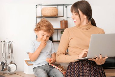 Küçük oğluyla mutfakta çalışan bir anne.