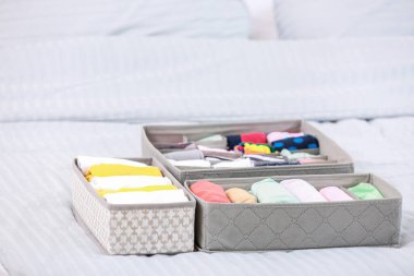 Yatakta temiz giysileri olan organizatörler.