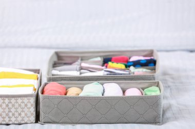 Yatakta temiz giysileri olan organizatörler.