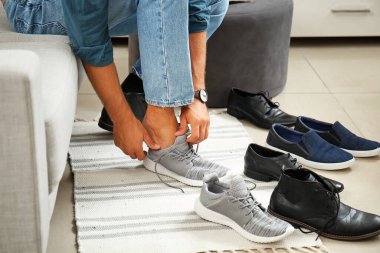 Modern mağazada yeni ayakkabılar seçen bir adam