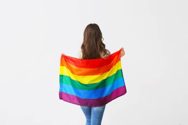 Hafif arkaplanda LGBT bayrağı olan genç bir kadın