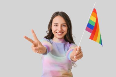 Hafif arkaplanda LGBT bayrağı olan genç bir kadın