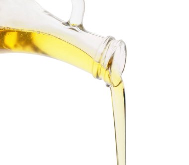 Beyaz arka planda şişeden taze zeytin yağı dökülüyor.