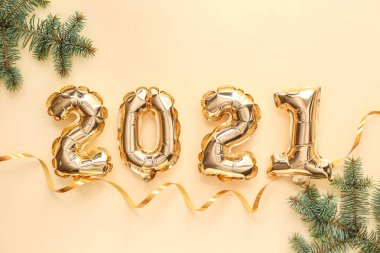 Şekil 2021 şeklindeki balonlar ve renk arkaplanındaki köknar dalları. Yeni yıl kutlaması