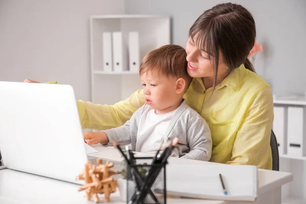 Working mother with little son in home office