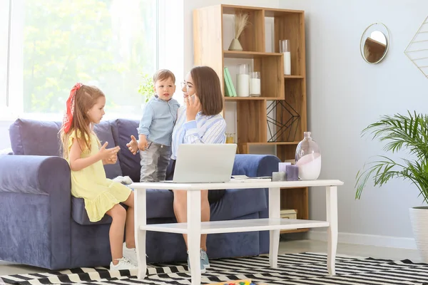 Working mother with little children at home