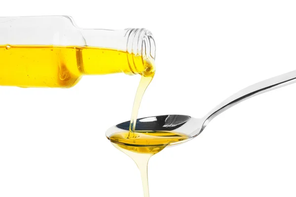 在白底上把新鲜橄榄油从瓶子倒进勺子里 — 图库照片