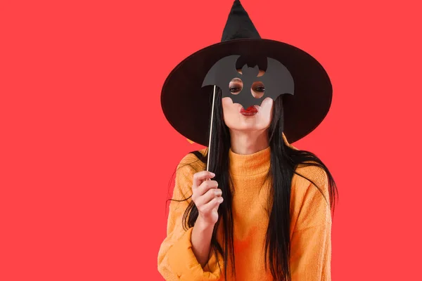 色の背景にハロウィーンの装飾を持つ美しい若い魔女 — ストック写真