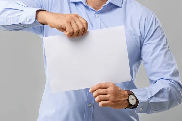 Mann Mit Leerem Blatt Papier Auf Grauem Hintergrund — Stockfoto