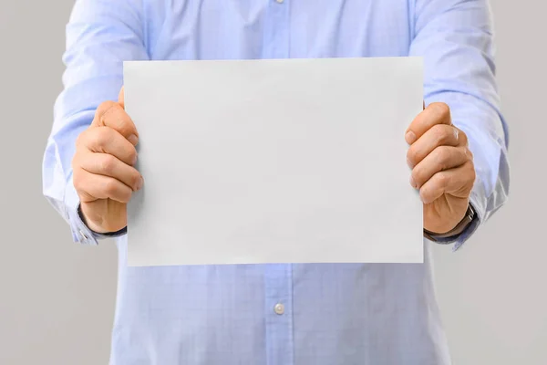 Mann Mit Leerem Blatt Papier Auf Grauem Hintergrund — Stockfoto