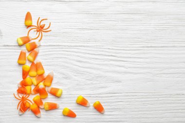 Beyaz ahşap arka planda lezzetli mısır şekerleriyle Cadılar Bayramı kompozisyonu