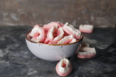 Karanlık arka planda Cadılar Bayramı için lezzetli ikramlarla dolu bir kase