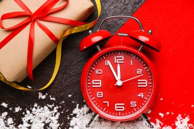 Çalar saat, kar, kart ve karanlık arka planda Noel hediyesi