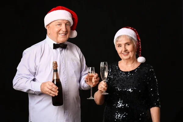 Пожилая Пара Шампанским Празднует Рождество Тёмном Фоне — стоковое фото